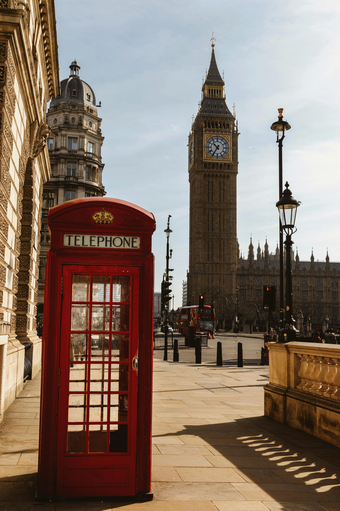 Cabine téléphonique rouge emblématique devant Big Ben à Londres, symbole du Royaume-Uni, idéale pour illustrer un article sur l’ETA UK et les formalités d’entrée en 2025.