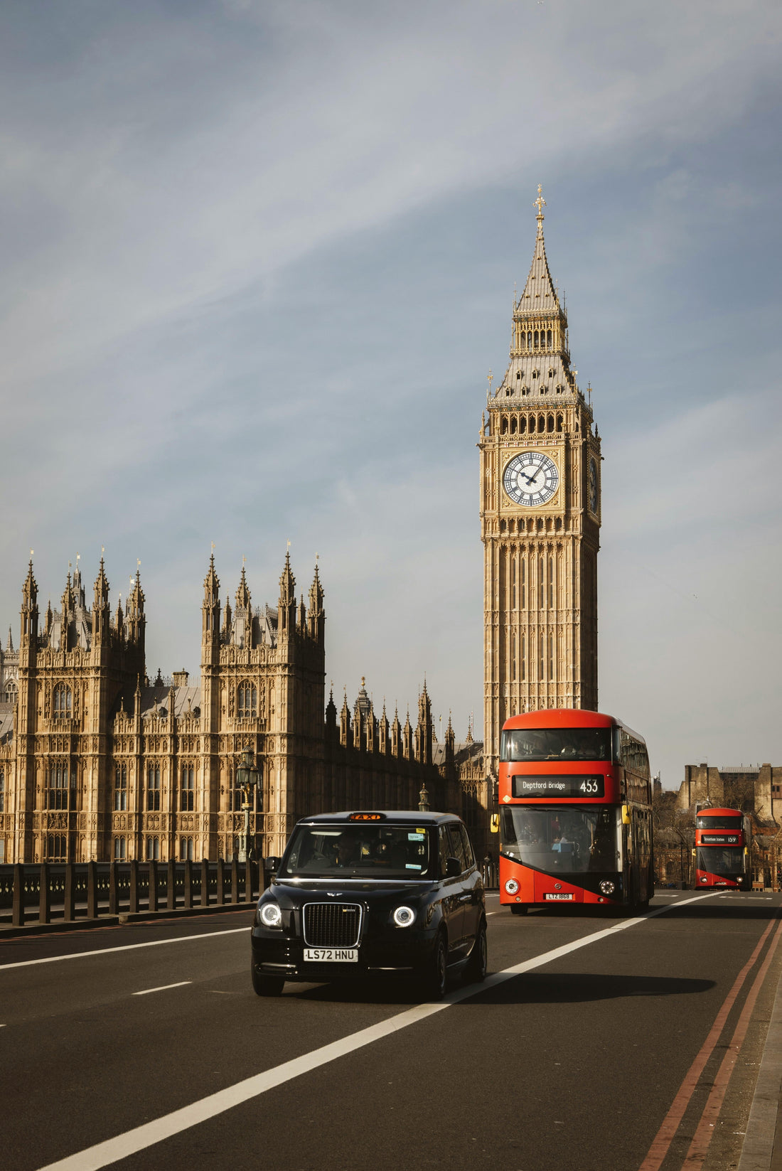 Vue emblématique du Parlement britannique et de Big Ben à Londres, avec un taxi noir londonien et un bus rouge traversant Westminster Bridge, symboles du Royaume-Uni et du tourisme au Royaume-Uni avec ETA.